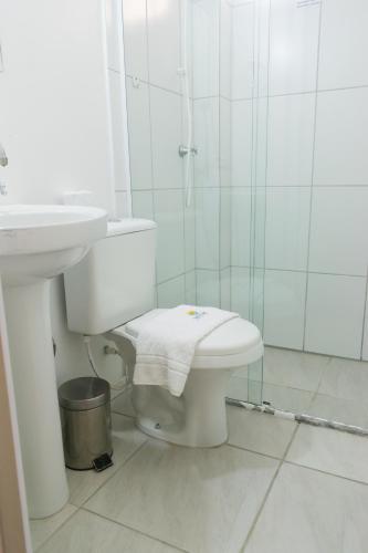 a bathroom with a toilet and a sink and a shower at Hotel Naturalis in Paranaguá