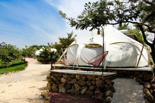 迪坡斯特蘭的住宿－Tendo Glamping，石墙上的圆顶帐篷,配有椅子