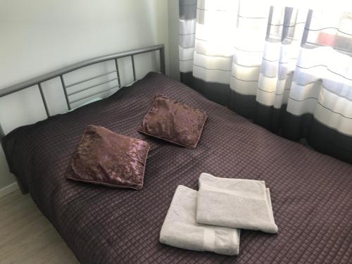 a bed with two pillows and towels on it at Apartament Lucky in Pruszcz Gdański