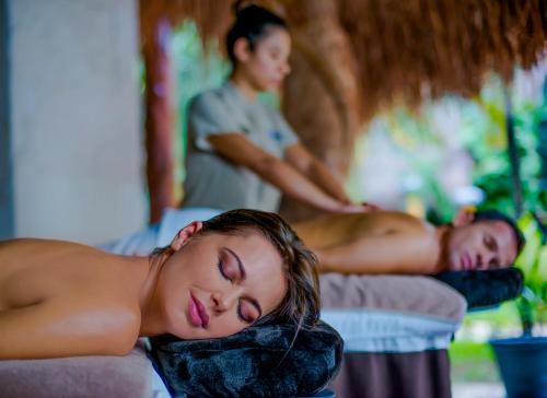 two women laying on their beds with a man in the background at Magic Blue Spa Boutique Hotel Adults Only in Playa del Carmen