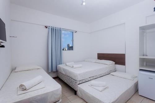 a room with two beds and a tv at Economy Apart in Natal