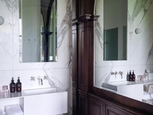 a bathroom with two sinks and two mirrors at Parc Broekhuizen l Culinair landgoed in Leersum
