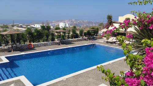 a swimming pool in a resort with pink flowers at Abelonas Village in Megalokhori