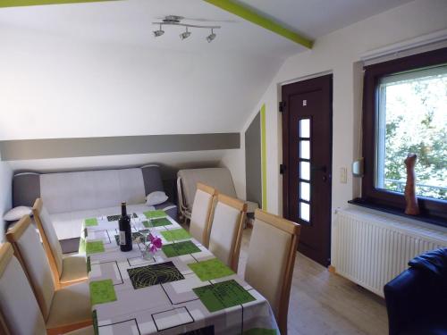 ein Esszimmer mit einem Tisch, Stühlen und einem Fenster in der Unterkunft Eifel Lodge in Bütgenbach
