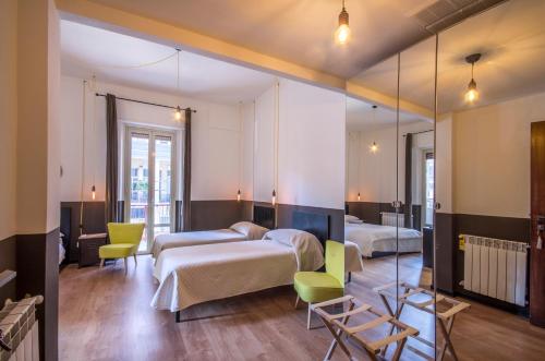 um quarto com duas camas e um espelho em QAL'AT Apart Hotel em Caltanissetta
