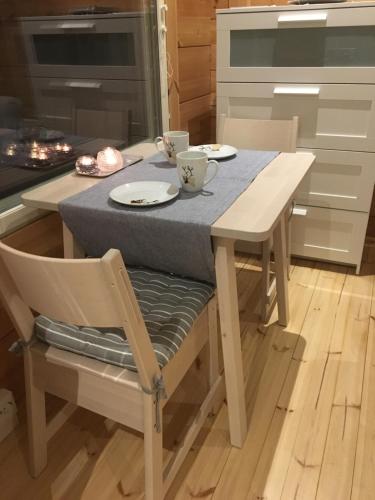 - une table avec deux tasses et des assiettes dans la cuisine dans l'établissement Villa Kaltio, à Äkäslompolo