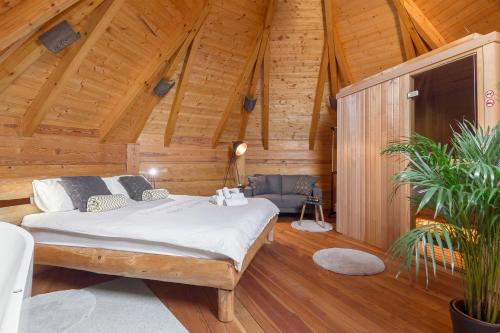 ein Schlafzimmer mit einem Bett in einer Holzhütte in der Unterkunft Wellness hiska Izabela in Križevci pri Ljutomeru