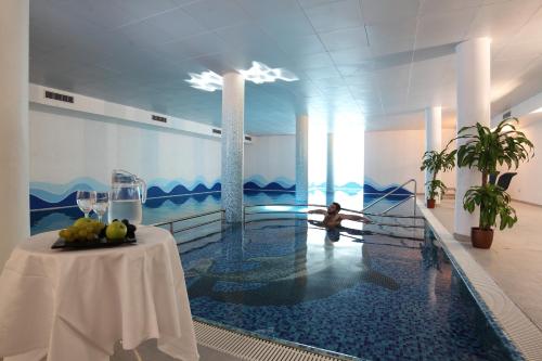 a swimming pool with a table in the middle of a building at My Kosher Hotel in Canazei