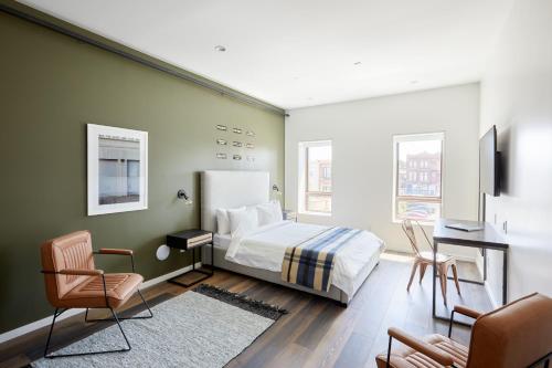 een slaapkamer met een bed, een bureau en stoelen bij Sonder The Queen in Philadelphia