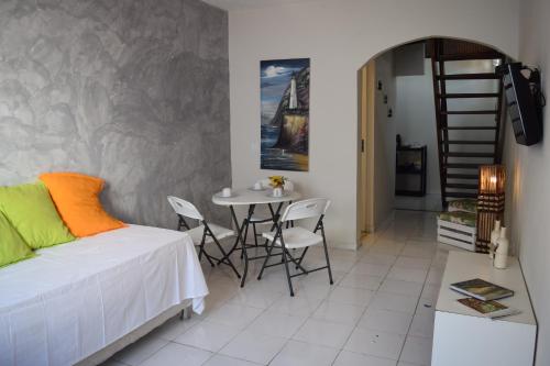 Flat Vila Aju في أراكاجو: غرفة نوم بسرير وطاولة وكراسي