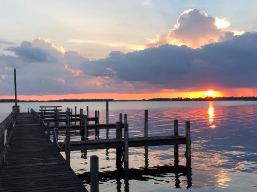 a group of benches on a dock in the water at sunset at Lakeside Inn and Cafe in Saint Cloud