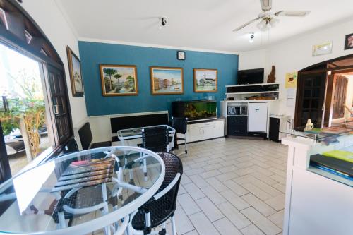 a living room with a glass table and a blue wall at Hotel Naturalis Eireli in Paranaguá