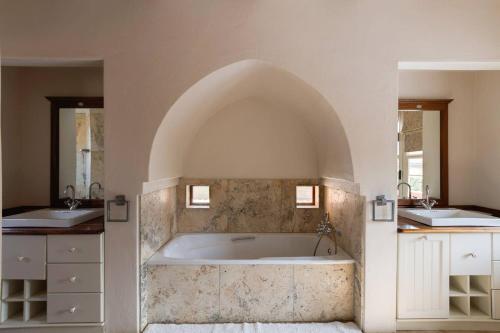 ein Badezimmer mit einer großen Badewanne und 2 Waschbecken in der Unterkunft Nooitgedacht Country House in Boesmanspad