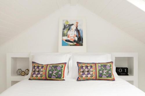 een witte slaapkamer met 2 kussens en een wit bed bij Casa da Maria Alfama in Lissabon