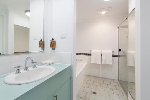 a white bathroom with a sink and a shower at Nu Leaf Retreat in Pokolbin