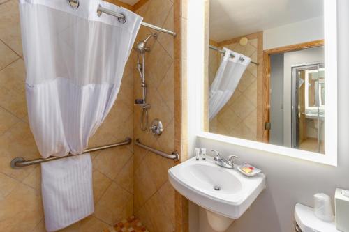 a bathroom with a sink and a toilet and a mirror at Red Lion Templin's Hotel on the River in Post Falls