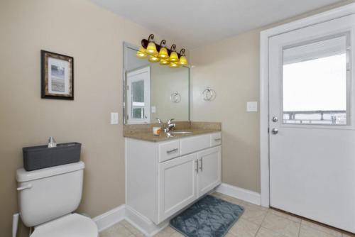 a bathroom with a toilet and a sink and a mirror at Water Front Delight On The Bay Home in Norfolk