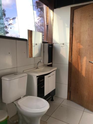 baño con aseo y lavabo y ventana en Hostel A Cozinha de Cora, en Brasilia