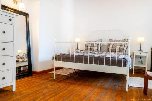 a bedroom with a bed with a mirror and a dresser at Apartamenty przy STONEHENGE in Sosnowiec