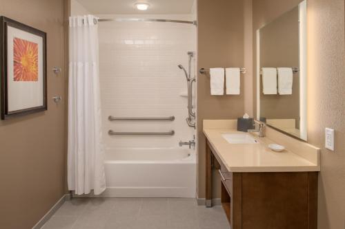 a bathroom with a tub and a sink and a shower at Staybridge Suites - Hillsboro North by IHG in Hillsboro
