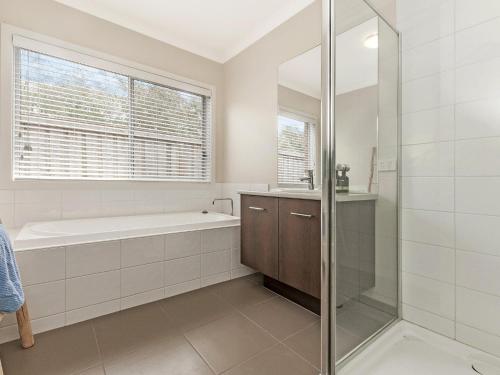 a bathroom with a shower and a tub and a sink at Little Croft in Port Fairy
