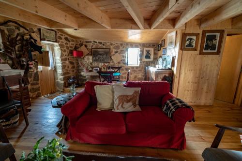 a red couch in a living room with wooden walls at Old House in Monsanto