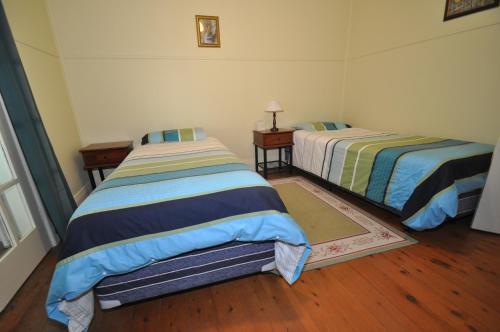
a bedroom with two beds and a desk at 12 Bluewater Drive in Kianga
