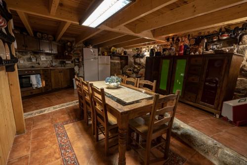a kitchen with a wooden table with chairs and a refrigerator at Old House in Monsanto
