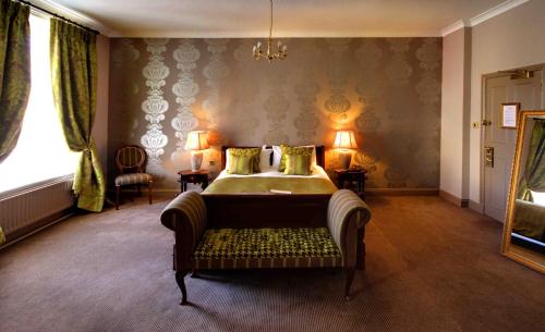 a bedroom with a bed and a couch in it at King's Head Hotel By Greene King Inns in Wimborne Minster