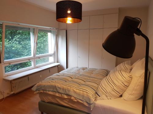 ハイデルベルクにあるHeidelloftのベッドルーム1室(ランプ付)、窓2つが備わります。