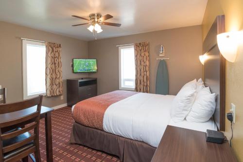 a hotel room with a bed and a flat screen tv at Capitol Hill Motel in Portland