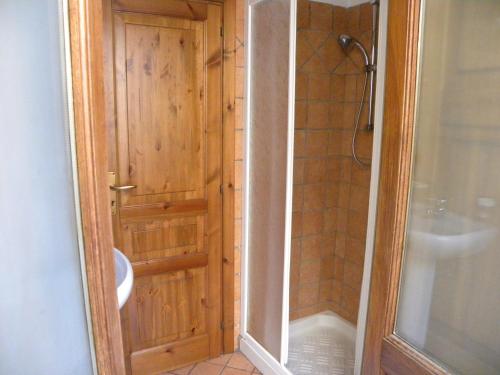 a bathroom with a shower and a wooden door at Case Vacanze Albamarina in Lipari