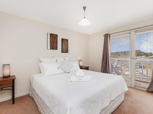 a white bedroom with a large bed and a window at Moyne Views 2 in Port Fairy