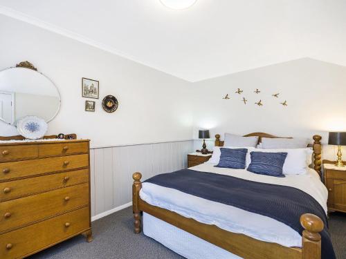 a bedroom with a bed and a mirror and a dresser at Pea Soup Beach in Port Fairy