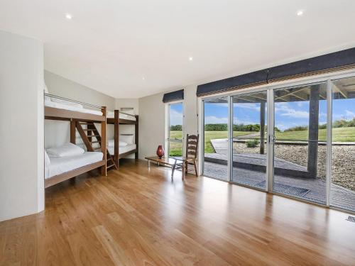 a bedroom with two bunk beds and sliding glass doors at Port Fairy Beach House in Port Fairy