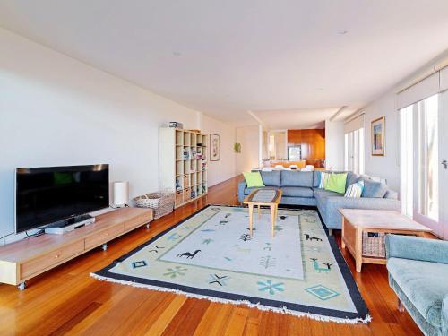 a living room with a couch and a tv at Rubys Beachfront in Port Fairy