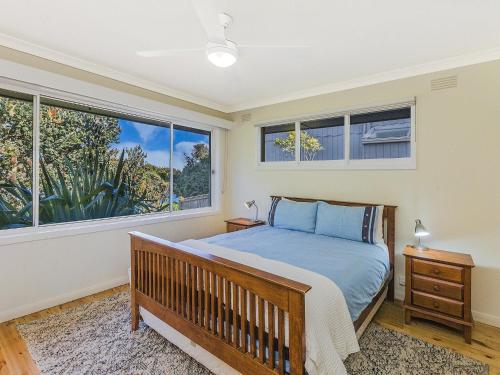 a bedroom with a bed and a large window at Rossleague House in Port Fairy