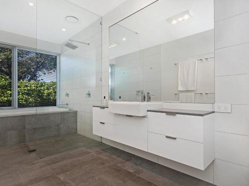 a white bathroom with a sink and a mirror at Saltwater Lodge in Port Fairy