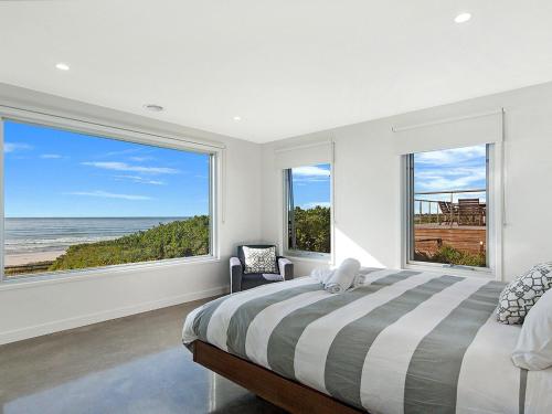 a bedroom with a bed and a view of the ocean at Saltwater Lodge in Port Fairy