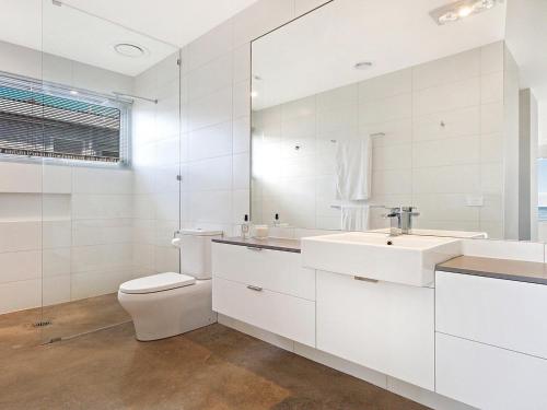 Un baño blanco con inodoro y lavabo. en Saltwater Retreat, en Port Fairy