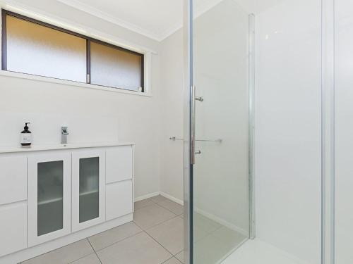 a bathroom with a glass shower and a sink at Seaclusion in Port Fairy