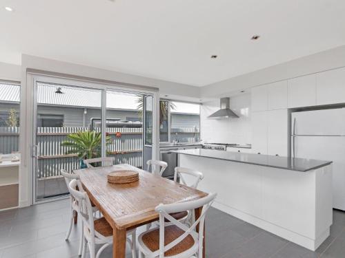 a kitchen and dining room with a wooden table and chairs at The Craic in Port Fairy