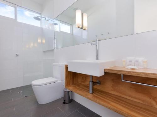 a white bathroom with a sink and a toilet at The Church in Port Fairy