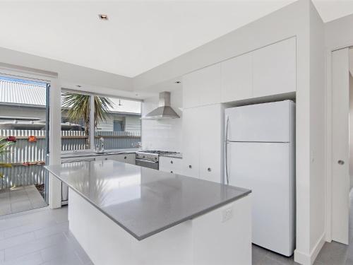a white kitchen with a stainless steel counter top at The Craic in Port Fairy