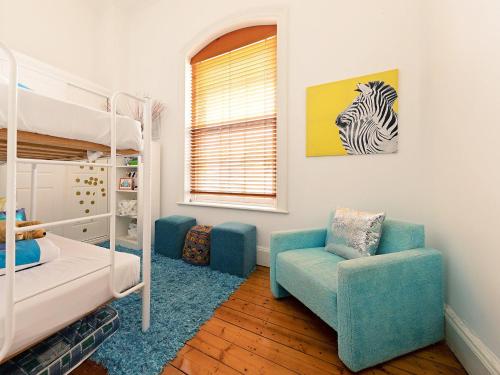 a bedroom with a bunk bed and a chair at The Ivy Bank in Port Fairy