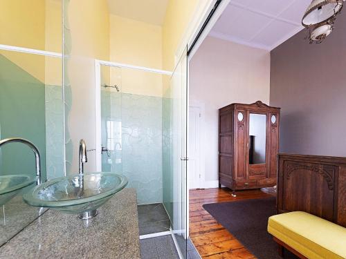 ein Badezimmer mit einem Glaswaschbecken und einer Dusche in der Unterkunft The Ivy Bank in Port Fairy