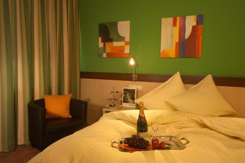 Bett mit einem Tablett mit Essen und einer Flasche Wein in der Unterkunft Hotel-Landgasthof Brachfeld in Sulz am Neckar