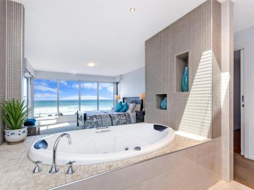 a bath tub in a bathroom with a view of the ocean at The Nushak in Port Fairy