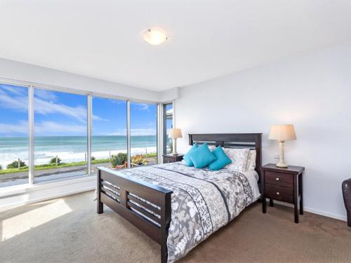 a bedroom with a bed with a view of the ocean at The Nushak in Port Fairy
