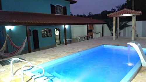 a swimming pool in front of a house at Bertioga-Costa do Sol MK9 in Praia Guaratuba
